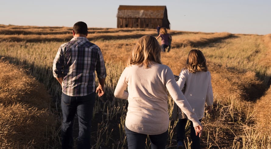 family walking in a grassy field