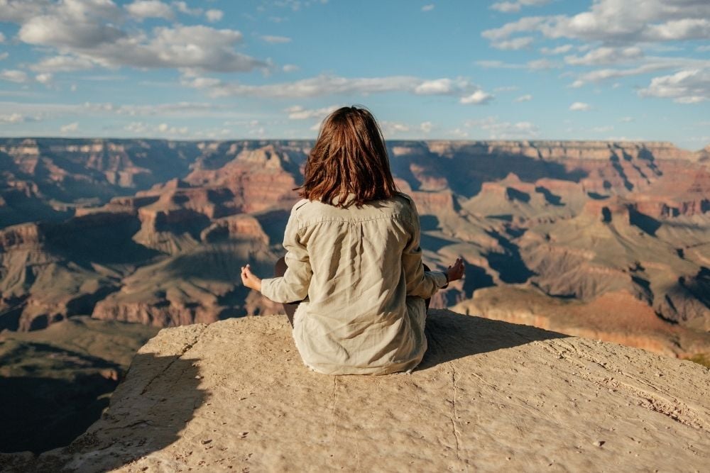woman meditating at grand canyon