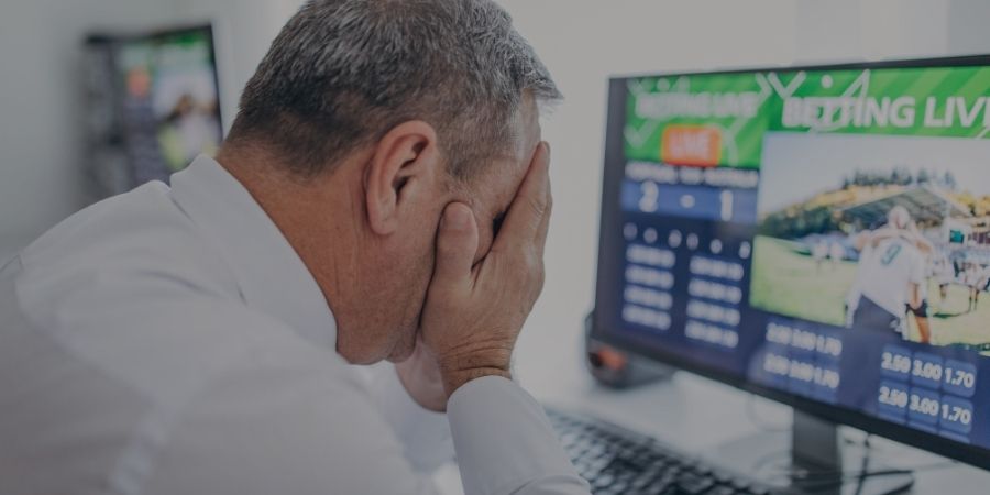 man head in hands after losing sports bet