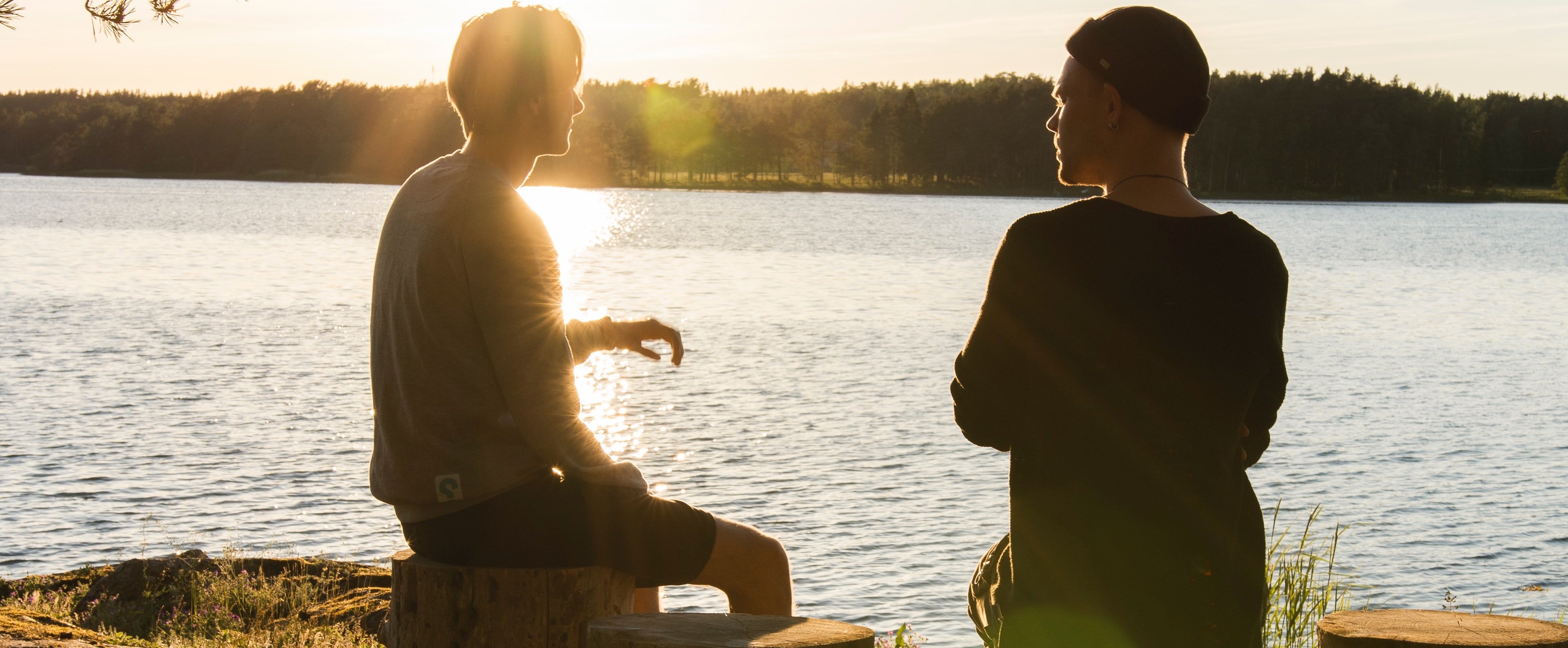two men talking by the lake